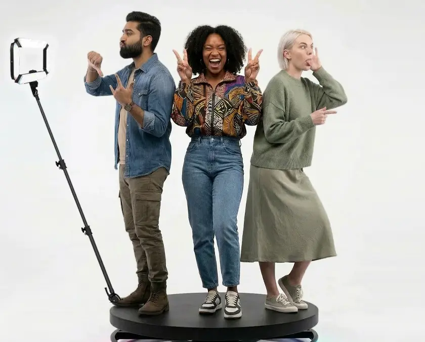 Guests posing on a 360 photo booth platform while the rotating camera records