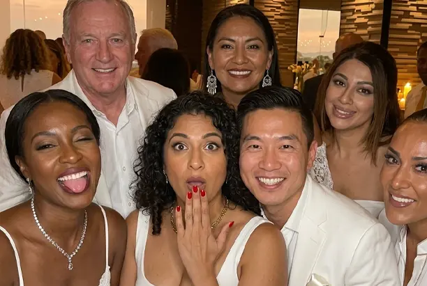 Candid group moment captured by roaming photo booth attendant — guests in white attire laughing at upscale Phoenix Arizona event — Ooh La La Booths roaming booth