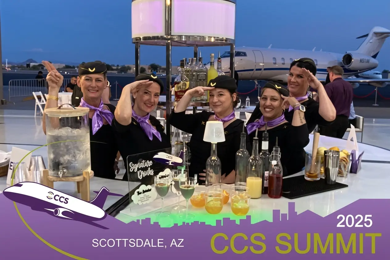 Roaming photo booth capture at CCS Summit 2025 corporate event in Scottsdale Arizona — staff in flight attendant uniforms at tarmac bar with private jet backdrop — Ooh La La Booths