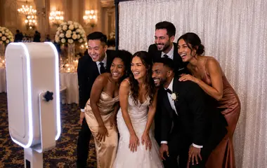 Bride, groom and wedding guests enjoying a photo booth at an Arizona wedding reception